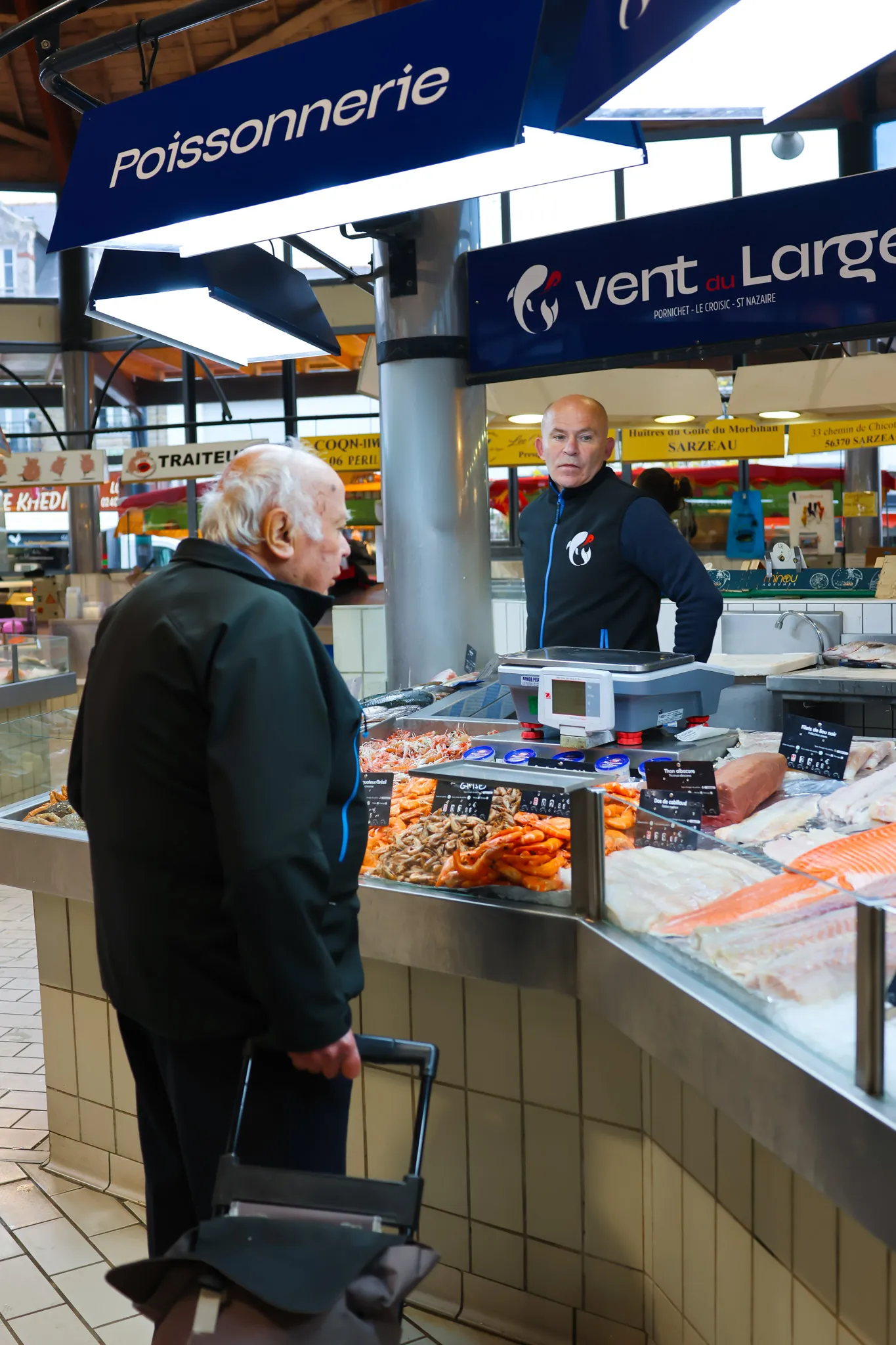 Conseil personnalisé : notre poissonnier échange avec un client fidèle au marché de Pornichet