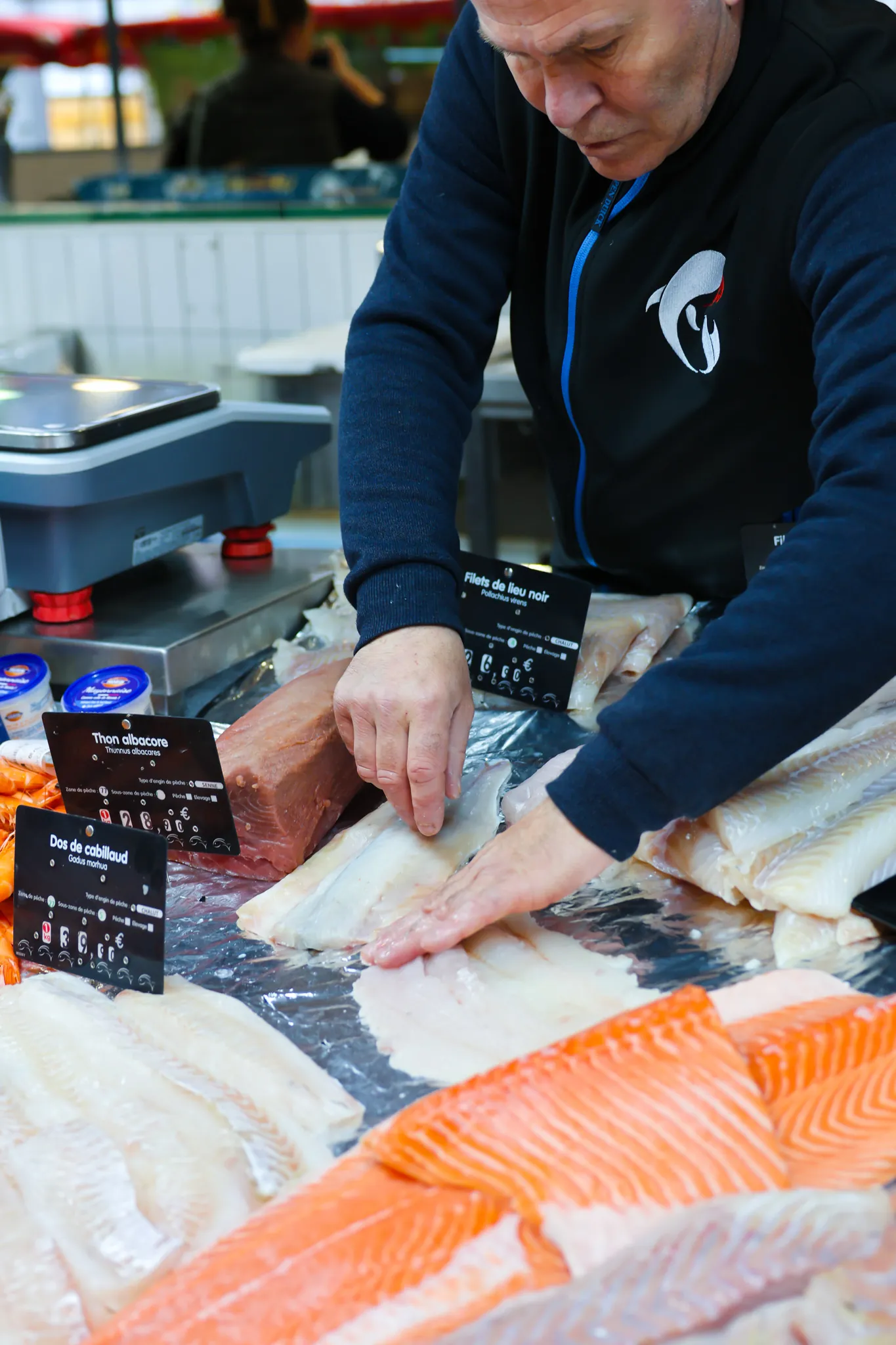 Notre poissonnier découpe avec précision un filet, garantissant une qualité irréprochable