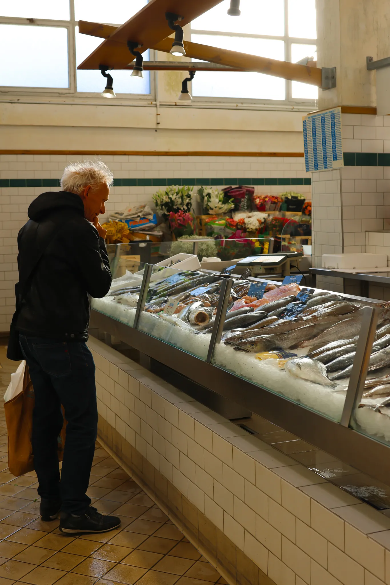 Client fidèle face à l'étal Vent du Large dans la halle du Croisic