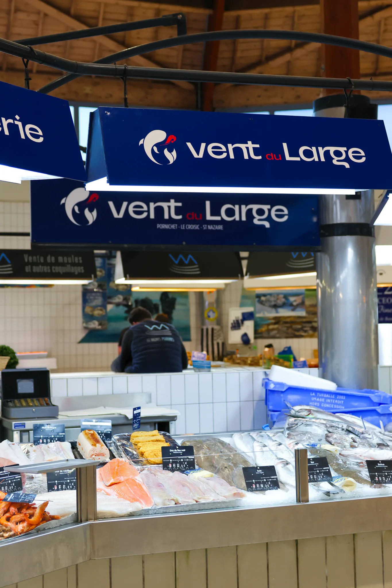 Enseignes Vent du Large suspendues au-dessus du stand à Pornichet, sous la halle